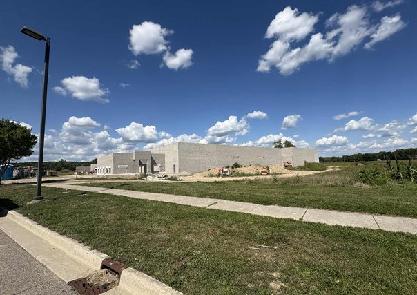 Campus Parkway looking toward the building, with completed road, curb, sidewalk, and lighting in place